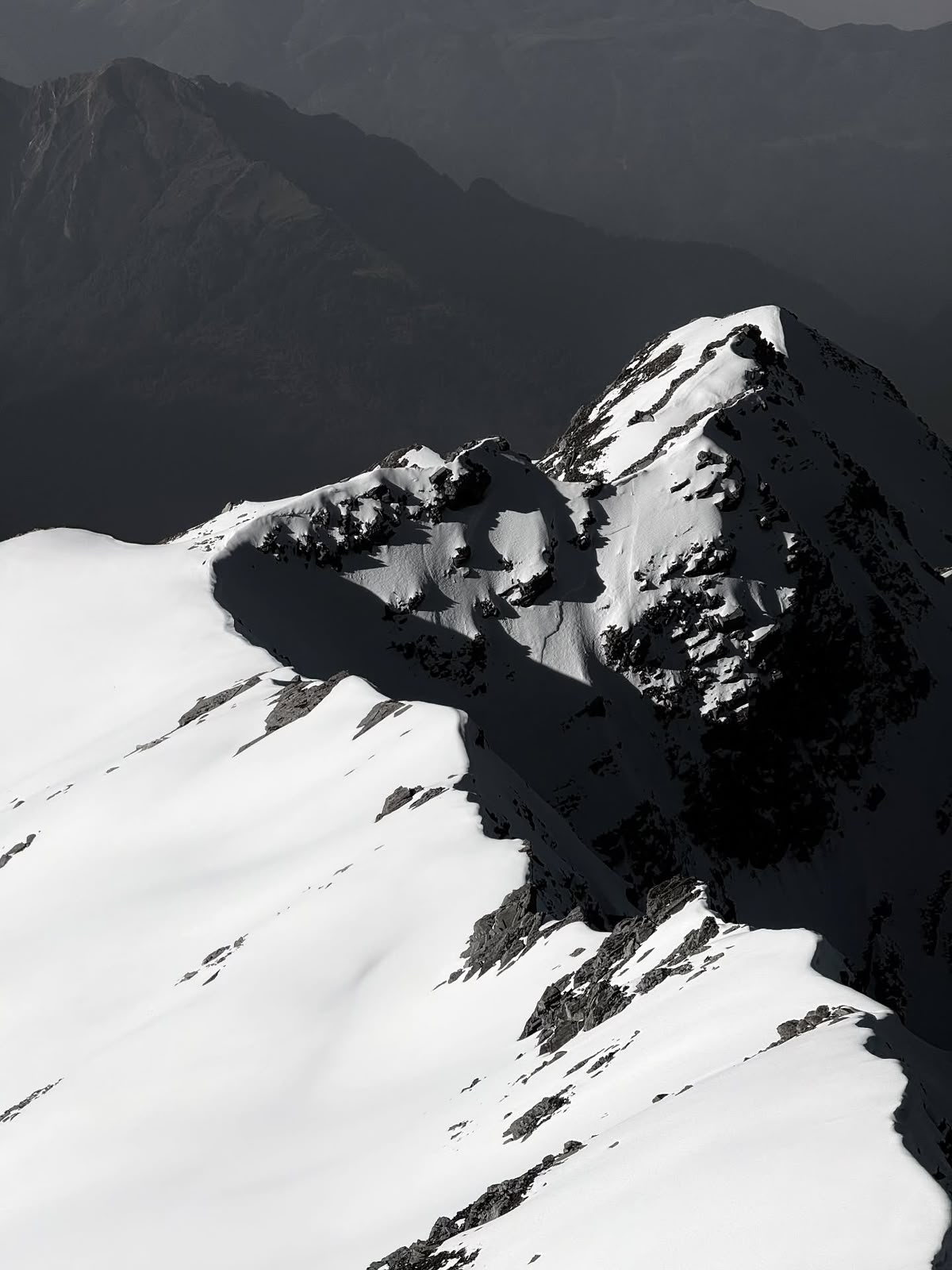 A corniced ridge falling away into the valley